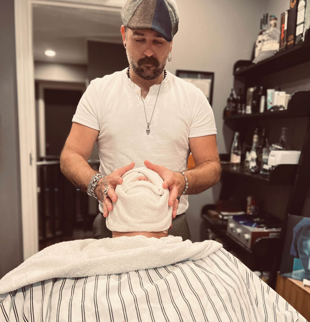 Client receives hot towel post-shave at The Moose Mens Grooming Lounge